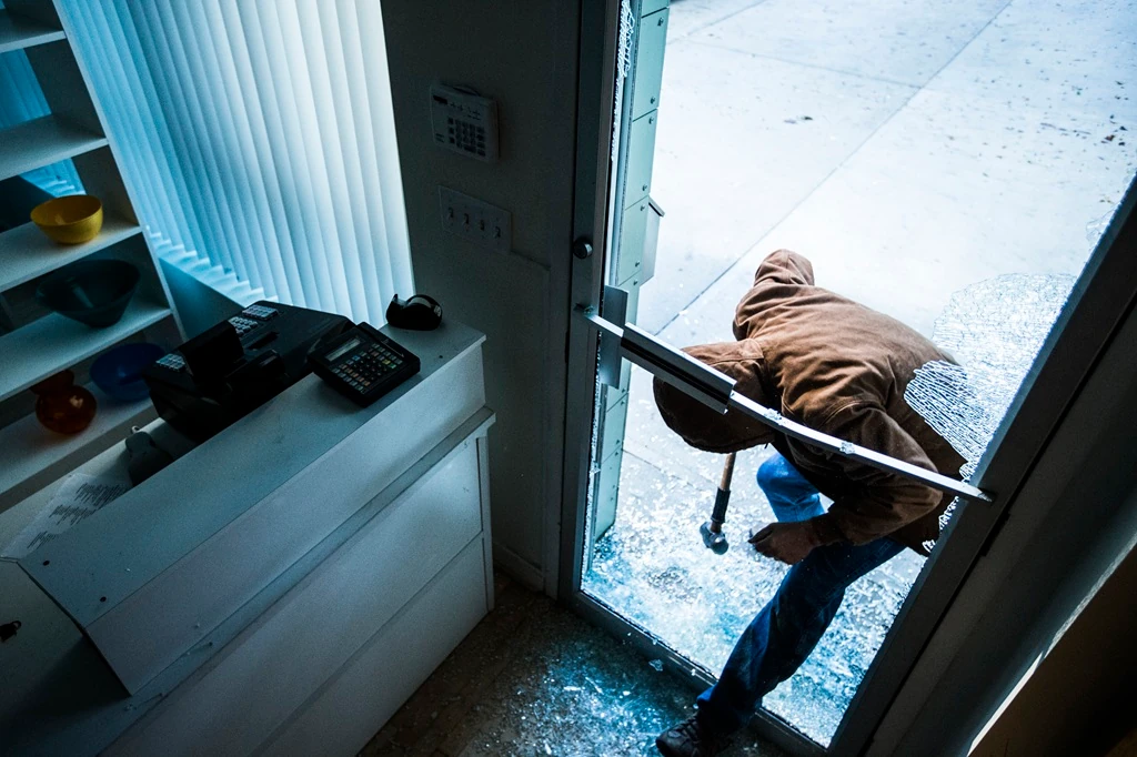 Burglar captured on video by Commercial Fire & Security Intrusion Detection system while breaking through a glass door